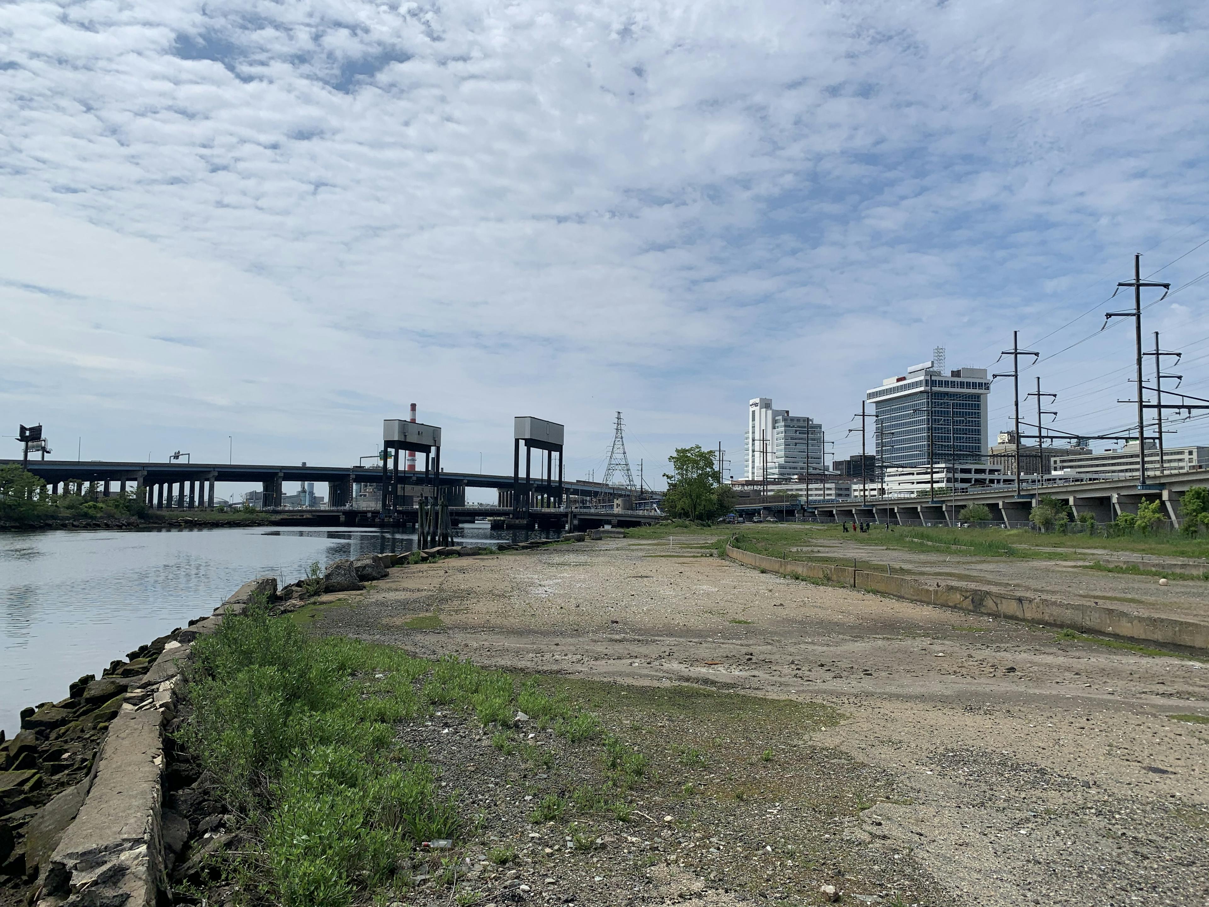 open lot with bridge and buildings in the background